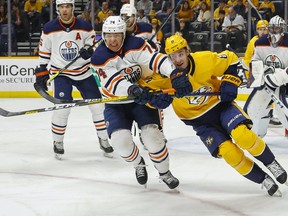 Ethan Bear of the Edmonton Oilers, left, and Kyle Turris of the Nashville Predators fight for position during the first period at Bridgestone Arena on March 02, 2020 in Nashville, Tennessee.