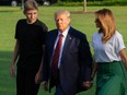 In this file photo taken on August 18, 2019, US President Donald Trump (C) First Lady Melania Trump (R) and their son Barron Trump (L) return to the White House after two weeks spent at Trump's golf club in New Jersey, in Washington, DC. -