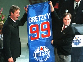 The greatest Edmonton Oilers and National Hockey League (NHL) player of all time, Wayne Gretzky, with the help of his long-time, close friend Edmonton Oilers locker-room attendant Joey Moss, hold up Gretzky's mini-replica version of the banner at No. 99's number retirement and banner raising night on Oct. 1, 1999, at Northlands Coliseum.
