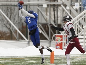 Ajou Ajou (6), seen here playing receiver with the Harry Ainlay Titans, stretches for a pass under coverage from the Bellerose Bulldogs' Travis Heggart (86) during the Alberta Tier 1 regional final at Clarke Stadium on Nov. 18, 2017.