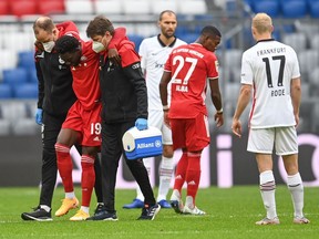 Bayern Munich's Canadian midfielder Alphonso Davies is helped off injured at the start of the German first division Bundesliga football match between FC Bayern Munich and Eintracht Frankfurt on Oct. 24, 2020 in Munich, southern Germany.