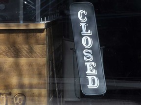 In this file photo, a sign is posted in a business that was temporarily closed due to the coronavirus pandemic.
