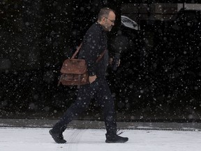 A pedestrian makes their way through the falling snow along 102 street near Jasper Avenue,  Oct. 23, 2020.