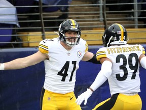 Pittsburgh Steelers linebacker Robert Spillane celebrates with free safety Minkah Fitzpatrick after returning an interception for a touchdown.