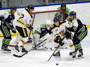 Old Grizzlys Dawson Leroux, middle, fights for the possession of the puck with Calgary Canucks Connor Bertamini, right, during the Alberta Junior Hockey League in Max Bell Arena on Wednesday, October 14, 2020.