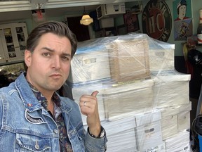 Alex Archbold stands in front of a collection of rare cowboy comic books that he purchased out of a storage locker near Calgary. Photo submitted.