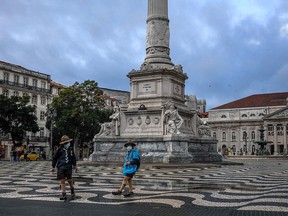 Two scouts wearing masks stand at the almost empty Rossio square in downtown Lisbon on November 7, 2020.