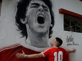 A fan reacts while mourning the death of soccer legend Diego Armando Maradona, outside the Diego Armando Maradona stadium, in Buenos Aires, Argentina November 25, 2020.