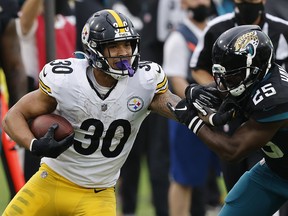James Conner of the Pittsburgh Steelers stiff-arms D.J. Hayden of the Jacksonville Jaguars at TIAA Bank Field on November 22, 2020 in Jacksonville.