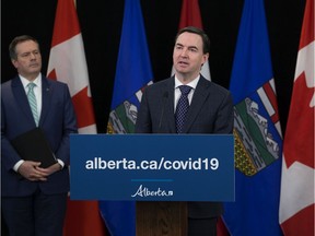 Premier Jason Kenney looks on as Minister of Labour and Immigration Jason Copping announces changes to the Employment Standards Code, during a press conference in Edmonton Monday April 6, 2020. Photo by David Bloom