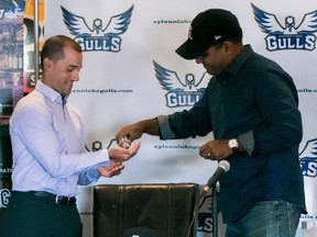 Sylvan Lake Gulls head coach Jason Chatwood, left, gets a shot of hand sanitizer from team general manager Aqil Samuel during a recent media event at Hockey Central Sports Lounge in Sylvan Lake, ahead of what is scheduled to be the club's inaugural season in the Western Canadian Baseball League this summer.