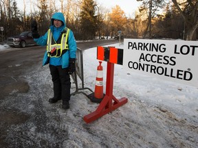 Duane Schade stands at the entrance to the Victoria Park parking lot on Dec. 12, 2020.  He works for the city and is making sure that there are no more than 70 cars in the lot. Other city employees are watching to make sure that groups of people are not gathering on the rink or in the pavilion.