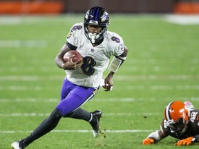 Baltimore Ravens quarterback Lamar Jackson (8) runs the ball past Cleveland Browns strong safety Karl Joseph (42) during the second quarter at FirstEnergy Stadium Dec 14, 2020.