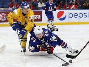 Max Jones #49 of United States tries to control the puck as Jacob Moverare #27 of Sweden defends in the second period during the IIHF World Junior Championship at KeyBank Center on January 4, 2018 in Buffalo, New York.