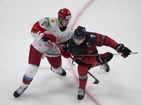 Canada's Kirby Dach (7) and Russia's Danil Chaika (5) battle for the puck  during second period IIHF World Junior Hockey Championship pre-competition action on Wednesday, Dec. 23, 2020 in Edmonton.