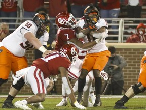 Oklahoma Sooners defensive end Ronnie Perkins (7) tackles Oklahoma State Cowboys running back LD Brown (0) at Gaylord Family-Oklahoma Memorial Stadium on Nov. 21, 2020.