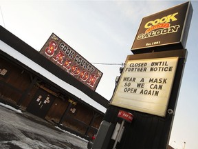 A sign states Cook County Saloon is temporarily closed due to new COVID-19 restrictions. A new report from Statistics Canada shows Edmonton has the highest unemployment rate among major Canadian cities at 12 per cent.