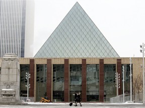 Pedestrians wearing masks to protect against COVID-19 as they walk past City Hall, in Edmonton Monday Nov. 23, 2020.