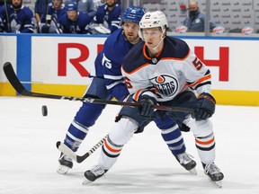 Kailer Yamamoto #56 of the Edmonton Oilers skates against Alexander Kerfoot #15 of the Toronto Maple Leafs during an NHL game at Scotiabank Arena on January 22, 2021 in Toronto.