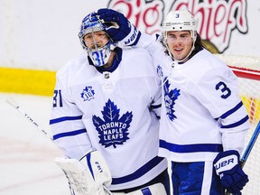Frederik Andersen (31) and Justin Holl (3) of the Toronto Maple Leafs celebrate after defeating the Calgary Flames at Scotiabank Saddledome on Jan. 26, 2021.