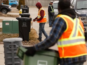 Workers deliver new waste carts in the Ellerslie neighbourhood as part of the collection pilot project in April 2019. Photo by Ian Kucerak/Postmedia