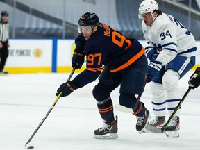 Edmonton Oilers’ Connor McDavid (97) battles Toronto Maple Leafs’ Auston Matthews (34) during first period NHL action at Rogers Place in Edmonton, on Thursday, Jan. 28, 2021.
