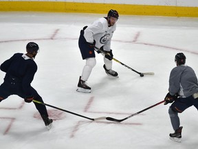 Oilers Connor McDavid freezes Darnell Nurse (25) and Kyle Turris (8) during training camp in preparation for opening night Wednesday at Rogers Place in Edmonton, January 12, 2021. Ed Kaiser/Postmedia