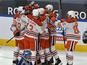 Edmonton Oilers surround Connor McDavid (97) to celebrate his overtime goal against the Toronto Maple Leafs to win 4-3 during NHL action at Rogers Place in Edmonton, January 30, 2021. Ed Kaiser/Postmedia