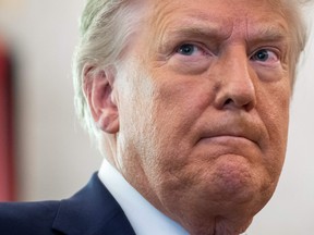 In this file photo taken on Dec. 7, 2020, U.S. President Donald Trump looks on during a ceremony presenting the Presidential Medal of Freedom to wrestler Dan Gable in the Oval Office of the White House in Washington, D.C.