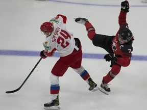 Canada's Kirby Dach (7) is upended by Russia's Ilya Safonov (24) during the IIHF world junior championships pre-competition on Dec. 23, 2020 in Edmonton.