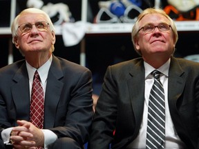 Former Oilers coaches John Muckler, left and Glen Sather watch video highlights of past glory moments on an overhead screen at the Heritage Classic on Nov. 21, 2003.