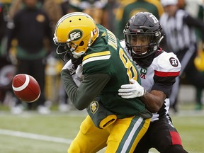 Former Edmonton wide receiver D'haquille Williams (left) drops the ball as he is tackled by Ottawa Redblacks defensive back Jonathan Rose at Commonwealth Stadium on Oct. 13, 2018.