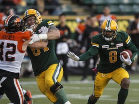 Edmonton Football Team quarterback Troy Williams (8) runs the ball against B.C. Lions' Kevin Haynes (42) with help from right tackle Colin Kelly (67) at Commonwealth Stadium in this file photo from Oct. 12, 2019.