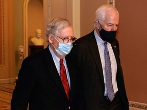 U.S. Sen. Majority Leader Mitch McConnell (R-KY), left, walks with U.S. Sen. John Cornyn (R-TX) from the Senate floor to his office after a vote on nomination of Brian Noland to be a Member of the Board of Directors of the Tennessee Valley Authority on Capitol Hill in Washington, D.C., Dec. 20, 2020.