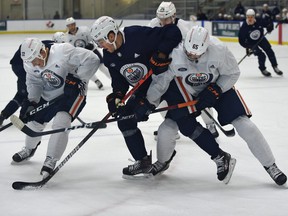 Oilers Kyle Turris (8) gets sandwiched between Tyson Barrie (22) and Cooper Marody (65) during training camp at the downtown community rink in Edmonton, January 8, 2021.