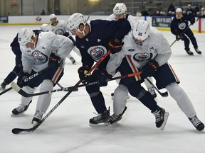 The Edmonton Oilers' Kyle Turris (8) gets sandwiched between Tyson Barrie (22) and Cooper Marody (65) during training camp at the downtown community rink in Edmonton on Jan. 8, 2021.