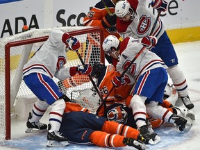 Montreal Canadiens players crowd the Edmonton Oilers crease trying to jam the puck past goalie Mikko Koskinen (19) at Rogers Place in Edmonton on Jan. 18, 2021.