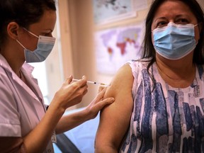 A woman receives the Pfizer BioNTech vaccine at the Pasteur Institute during a vaccination program, in Paris, on Thursday, Jan. 21, 2021.