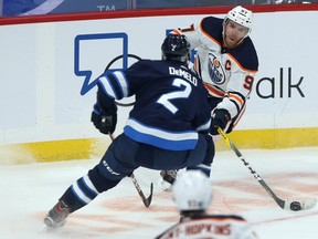 Edmonton Oilers centre Connor McDavid (right) is lined up by Winnipeg Jets defenceman Dylan DeMelo in Winnipeg on Tues., Jan. 26, 2021.