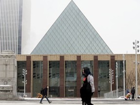Pedestrians walk past City Hall, in Edmonton Monday Nov. 23, 2020.
