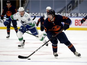 The Edmonton Oilers' Kailer Yamamoto (56) is chased by the Vancouver Canucks' Nate Schmidt (88) during first period NHL action, in Edmonton Thursday Jan. 14, 2021.
