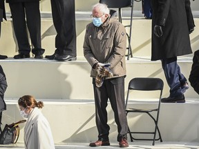 Sen. Bernie Sanders keeps his hands warm in mittens as he waits for Joe Biden to be sworn in.