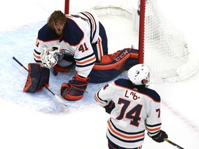 Mike Smith (41) of the Edmonton Oilers loses his mask against the Calgary Flames during an exhibition game prior to the 2020 NHL Stanley Cup Playoffs at Rogers Place on July 28, 2020.