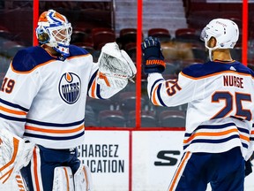 Edmonton Oilers goaltender Mikko Koskinen (19) is congratulated by teammate defenseman Darnell Nurse (25) after defeating the Ottawa Senators 3-2 at the Canadian Tire Centre on Feb. 9, 2021.