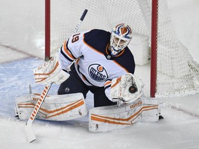 Edmonton Oilers goalie Mikko Koskinen (19) stops a shot from the Calgary Flames during the second period at Scotiabank Saddledome on Feb. 6, 2021.