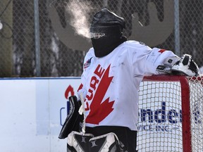 Nathan Finkbeiner wears a balaclava over his goalie mask because it has been so cold that pucks are shattering at the World's Longest Hockey Game which is over the halfway point raising funds for cancer research, out at Saiker's Acres near Sherwood Park, Wednesday, Feb. 10, 2021.