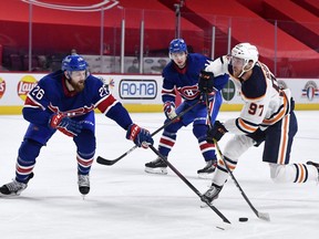 Edmonton Oilers forward Connor McDavid (97) shoots the puck as Montreal Canadiens defenseman Jeff Petry (26) defends during the third period at the Bell Centre on Feb. 11, 2021.