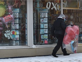 The Balloon Store seems prepared for the upcoming Valentine's Day this weekend as a woman walks away with a bag of balloons in Edmonton on Friday,  Feb. 12, 2021.