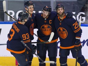 Edmonton Oilers Connor McDavid (97) celebrates his hat trick goal against the Calgary Flames with teammates  Ryan Nugent-Hopkins (93), Jesse Puljujarvi (13) and Darnell Nurse (25) during second period NHL action on Saturday, Feb. 20, 2021 in Edmonton.