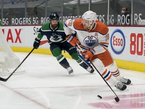 Vancouver Canucks defenseman Jordie Benn (8) defends Edmonton Oilers forward Leon Draisaitl (29) in the first period at Rogers Arena on Feb. 23, 2021.